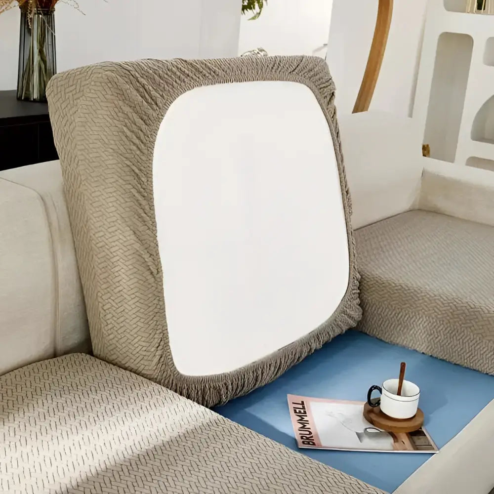 Beige herringbone sofa cushion cover with white panel and fringed edges paired with cream stretchy universal sofa cover