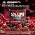 A jar of black-labeled creatine monohydrate muscle boost gummies with black lid surrounded by red and black berries