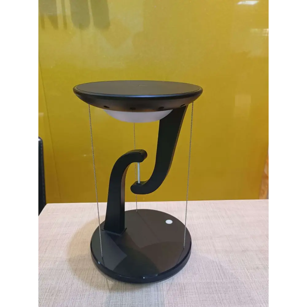 Black modern smart wireless phone charger suspension lamp with sleek curved base and circular top plate