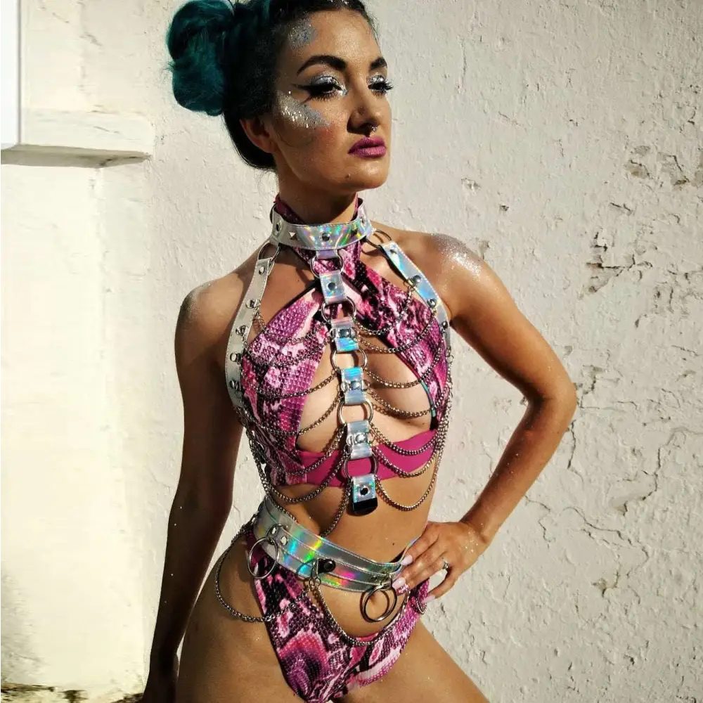 A creative versatile laser ladies belt bodysuit in vibrant pink and silver snakeskin with metallic chains and holographic accents
