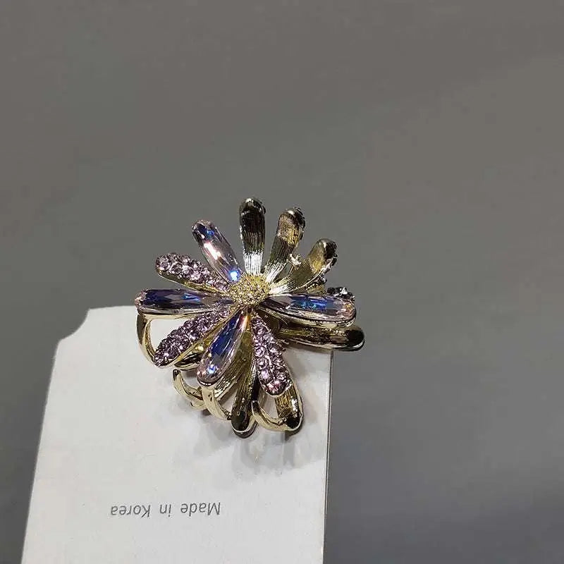 Crystal daisy metal gold-toned metal grab clip adorned with purple and blue rhinestones for a sweet accessory