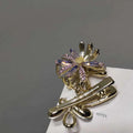 Gold-toned metal grab clip shaped like a flower with iridescent purple and clear rhinestones crystal daisy metal clip sweet accessory