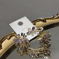 Gold-toned crystal daisy metal grab clip with floral design and sparkling purple and clear crystals clip sweet accessory