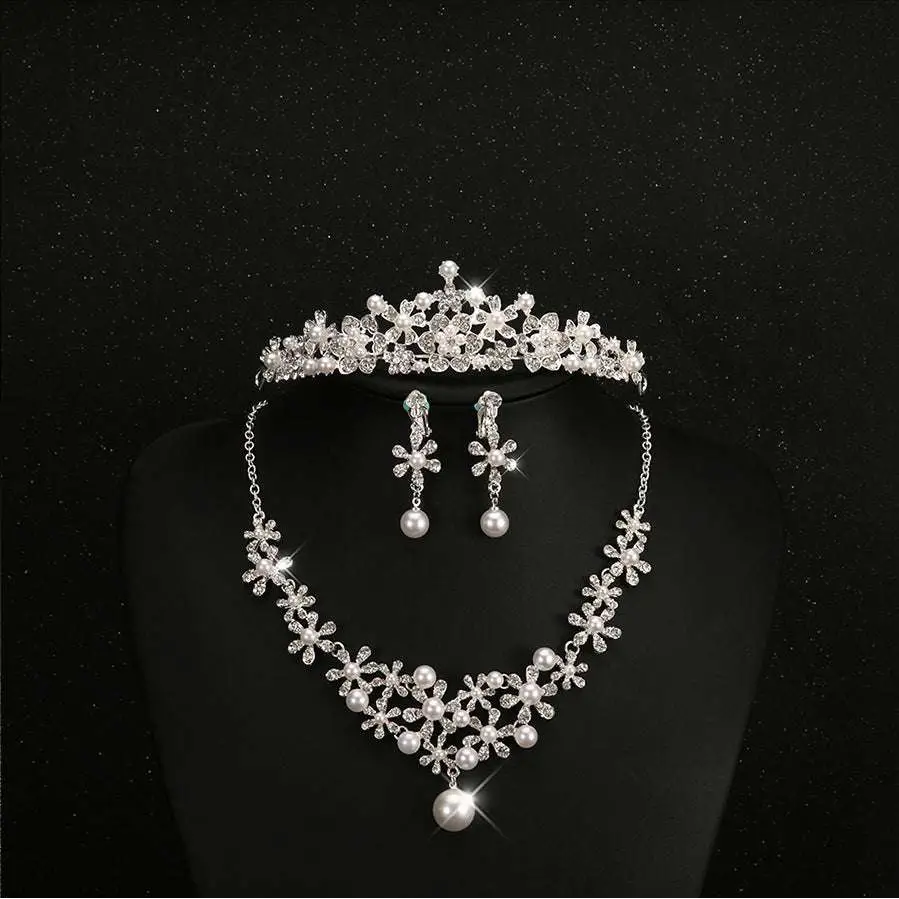 Sparkling silver bridal headdress set with clear crystals and pearls featuring a crystal flower necklace and earrings