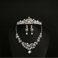 Silver floral tiara with sparkling crystals and pearls as part of a crystal flower necklace and bridal headdress set