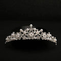 A delicate silver bridal headdress with sparkling crystals and white pearls in an elegant crystal flower pattern