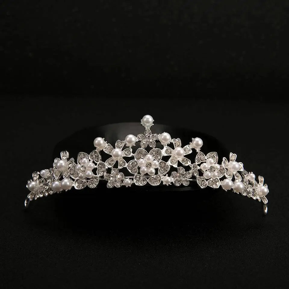 A delicate silver bridal headdress with sparkling crystals and white pearls in an elegant crystal flower pattern