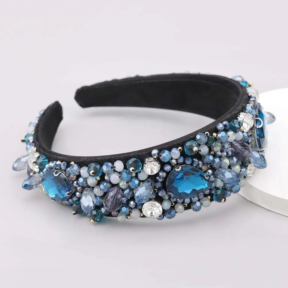 A black crystal geometric glass drill rhinestone headband adorned with blue and clear crystals in various sizes and cuts