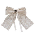 Ivory lace bow barrette with elegant crystal lace and central metallic button on satin ribbon tails for women