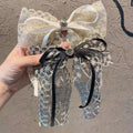 Delicate two-toned lace bow barrette with cream satin ribbon black velvet trim and elegant crystal lace central metallic button