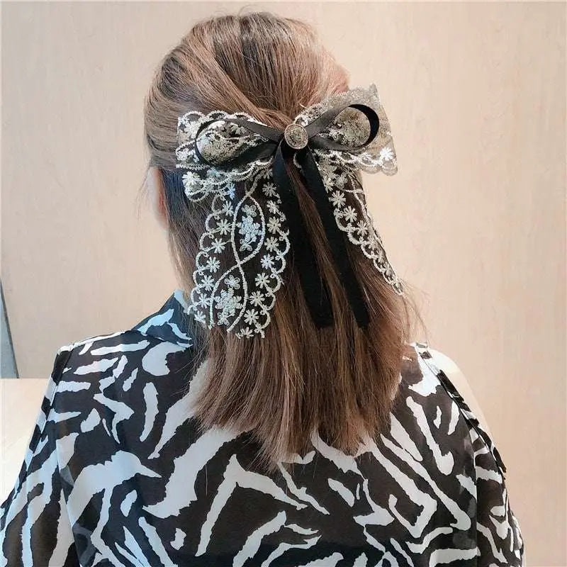 Elegant black lace bow barrettes with intricate silver floral embroidery and central metallic button for women