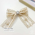 Crystal lace bow barrettes for women with delicate gold lace, cream satin ribbon, pearl floral center, and central metallic button