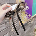 Elegant black and gold crystal lace bow barrettes for women with a central metallic button centerpiece