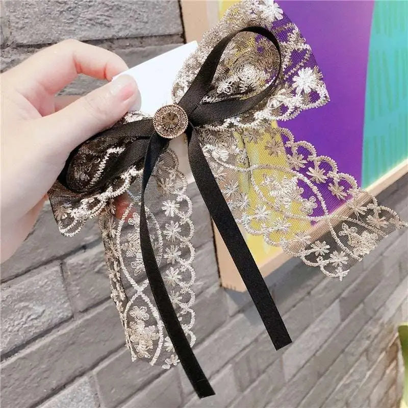 Elegant black and gold crystal lace bow barrettes for women with a central metallic button centerpiece