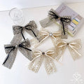 Elegant crystal lace bow barrettes in silver and cream with delicate bows and a central metallic button embellishment