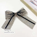 Elegant silver lace bow barrette with black satin ribbon and central metallic button for women’s crystal lace barrettes