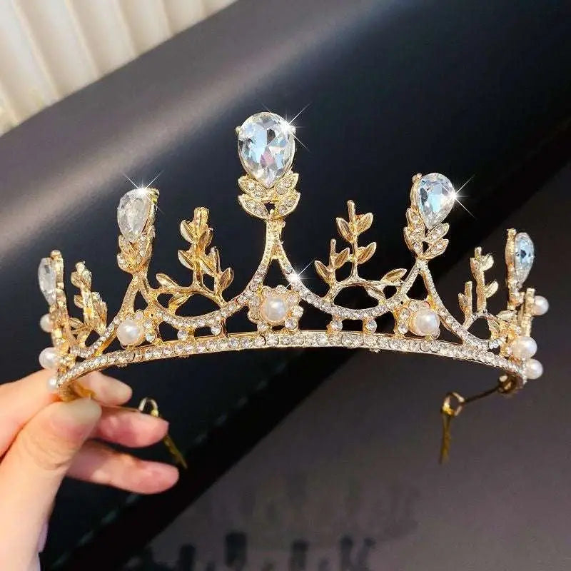 A golden crystal pearl girls princess crown headdress with clear teardrop crystals delicate leaves and pearls