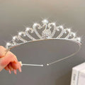 A sparkling silver crystal pearl girls princess crown headdress with heart-shaped crystals and a central peacock motif
