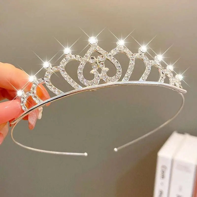 A sparkling silver girls princess crown headdress with clear rhinestones and heart-shaped cutouts for crystal pearl girls
