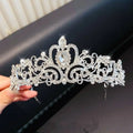 A sparkling silver crystal pearl girls princess crown headdress with floral patterns and a teardrop gemstone centerpiece