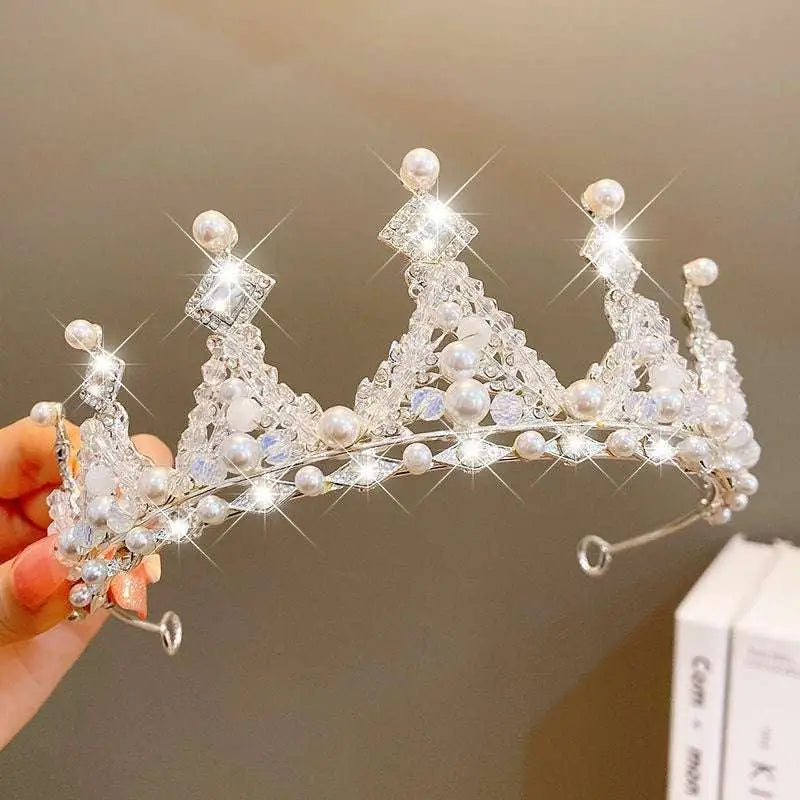 A sparkling silver girls princess crown headdress adorned with clear crystals and white pearls for special occasions