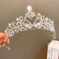 A sparkling silver girls princess crown headdress with intricate heart and leaf filigree adorned with clear crystals