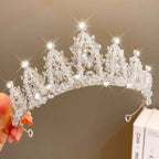 A sparkling silver crystal pearl girls princess crown headdress with intricate crystal embellishments and teardrop gemstone