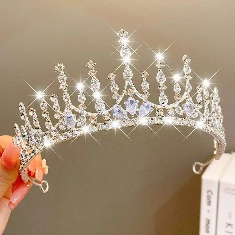 A sparkling silver girls princess crown headdress with clear and light blue crystal pearl teardrop crystals