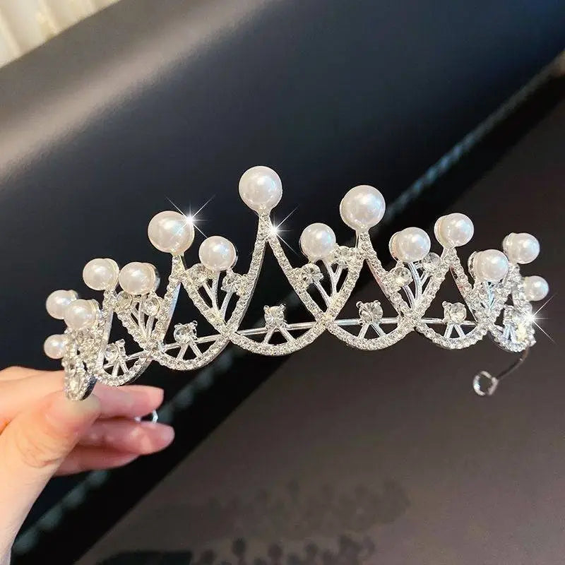 A sparkling silver girls princess crown headdress adorned with round white pearls and intricate crystal embellishments