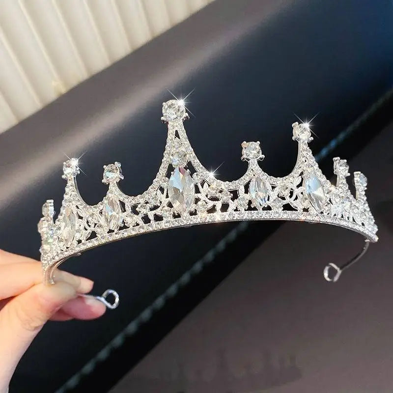 A sparkling silver girls princess crown headdress adorned with clear crystals and intricate lace-like metalwork
