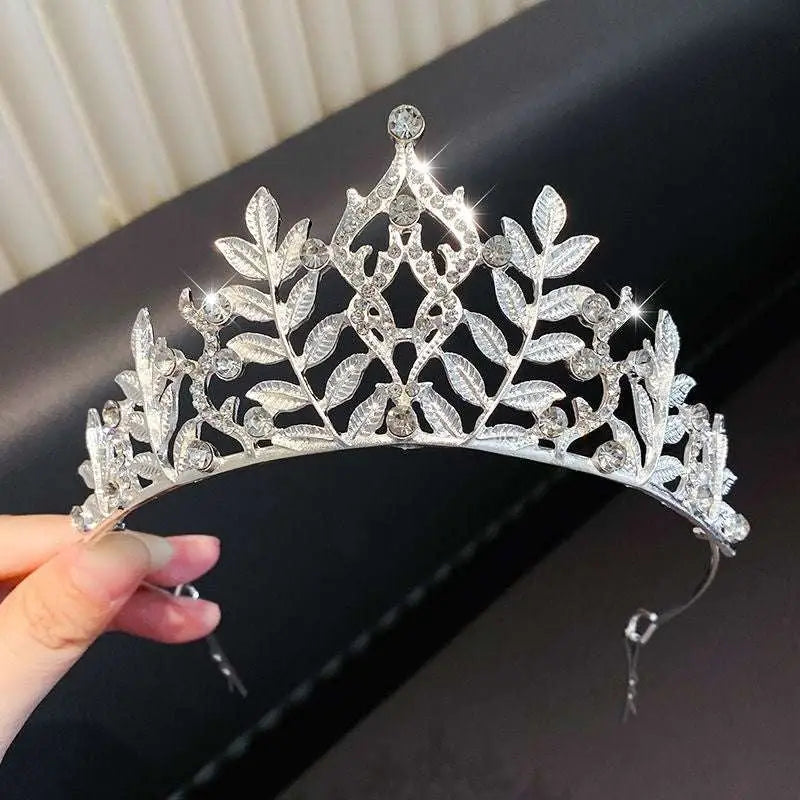 A sparkling silver girls princess crown headdress with intricate leaf designs and embedded crystals for crystal pearl girls