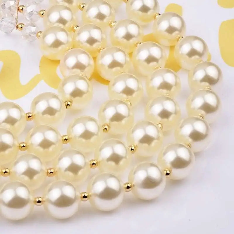 A crystal pearl long necklace featuring cream-colored imitation pearls separated by gold-toned spacers