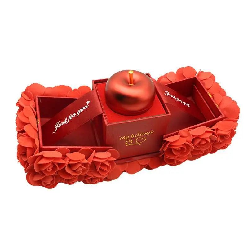 Red apple-shaped candle in an elegant gift box with rose petals complements crystal pendant necklace for everlasting love