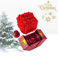 A vibrant red spherical bouquet of artificial roses in an elegant gift box with gold accents for everlasting love