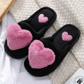 Black fuzzy cute love slipper with plush pink heart decorations and smaller embroidered hearts for winter warm plush use