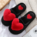 Black fuzzy cute love slipper with plush red heart decorations and smaller embroidered hearts for winter warmth