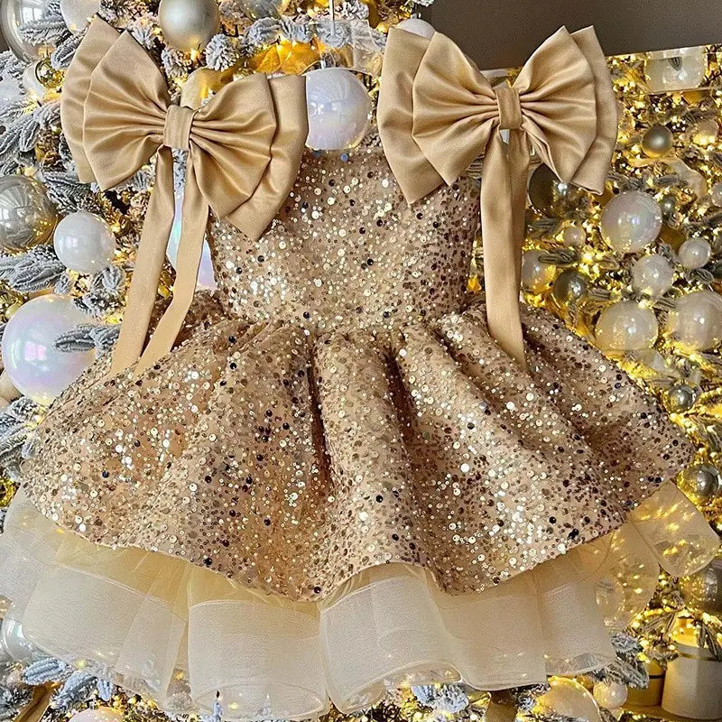 a shimmering gold sequined toddler princess dress red featuring a flared skirt with red tulle tutu and two large satin bows at the shoulders on the bow sleeves