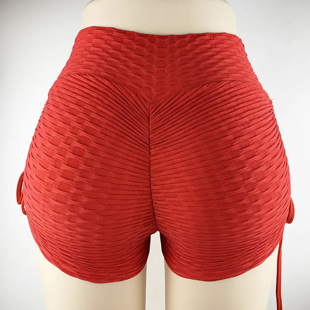 red textured high-waisted drawstring shorts with a sculpted ribbed design and side ties for a textured butt lift.