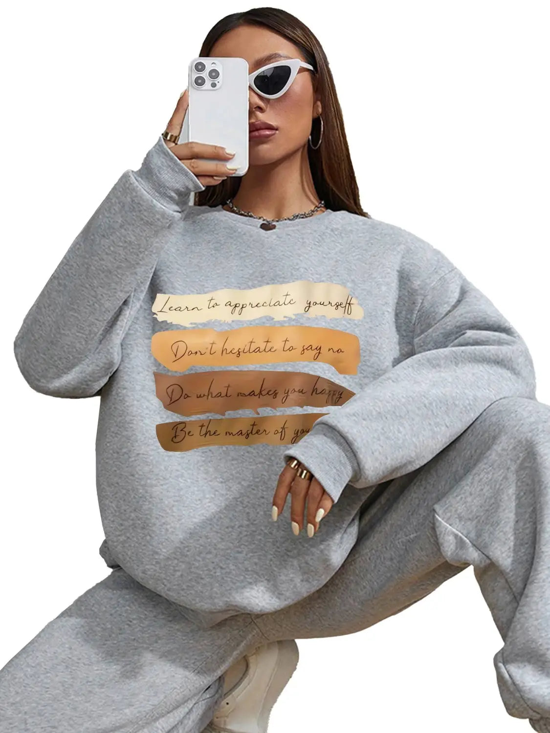 Gray oversized long sleeve sweatshirt with brown and beige motivational quote patches across the chest ideal for daily wear in a solid colour style.