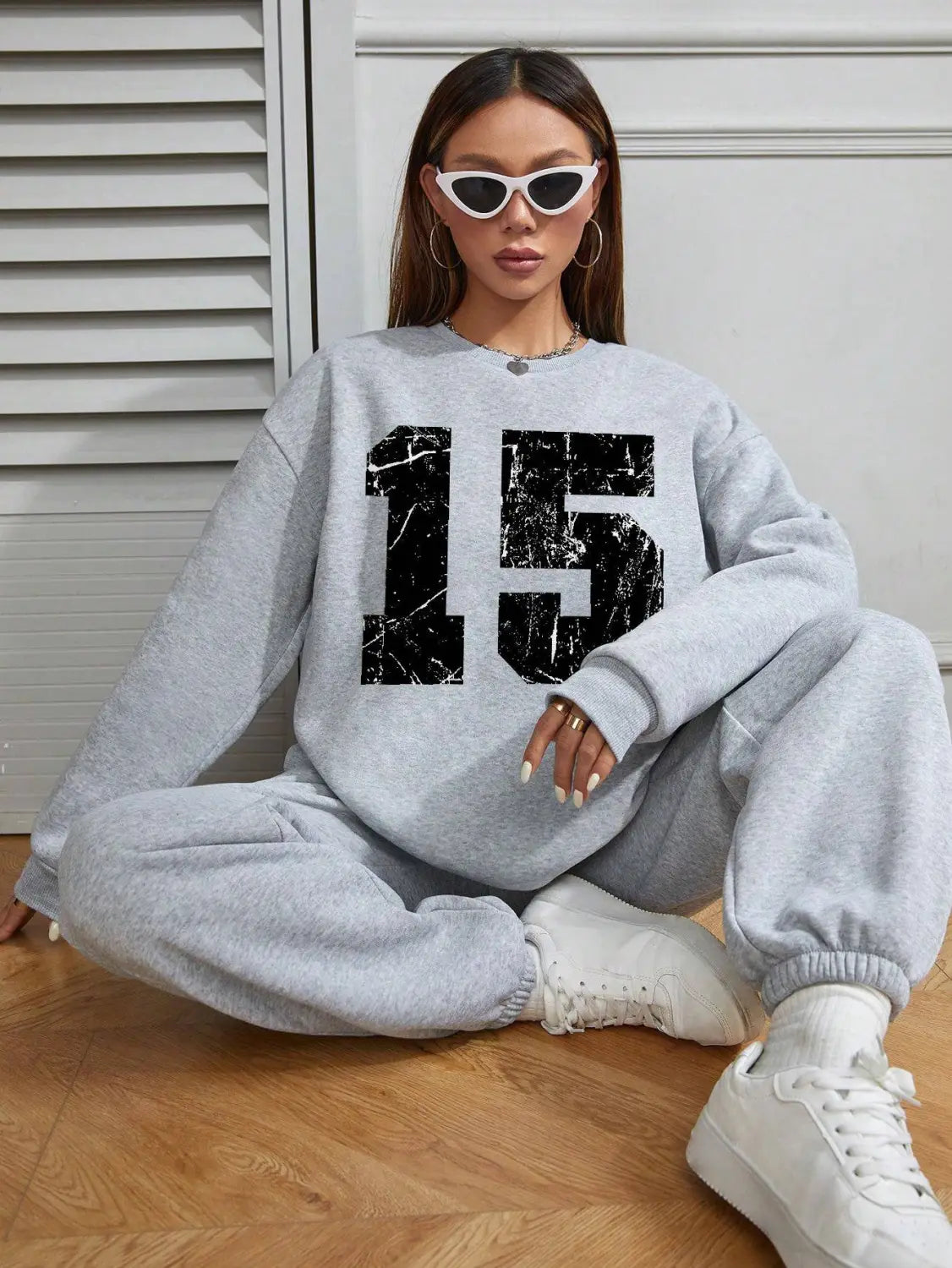 gray crew neck sweatshirt featuring a black distressed number 15 graphic on the front.