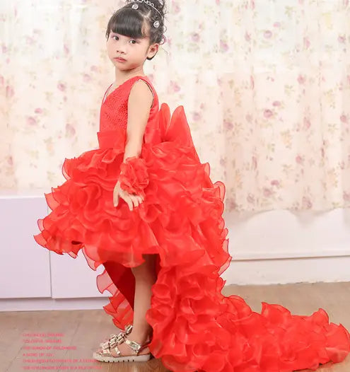 A vibrant fuchsia layered ruffled dress flower girl tuxedo featuring a trailing dress flower design with delicate lace detailing and a high-low hemline.