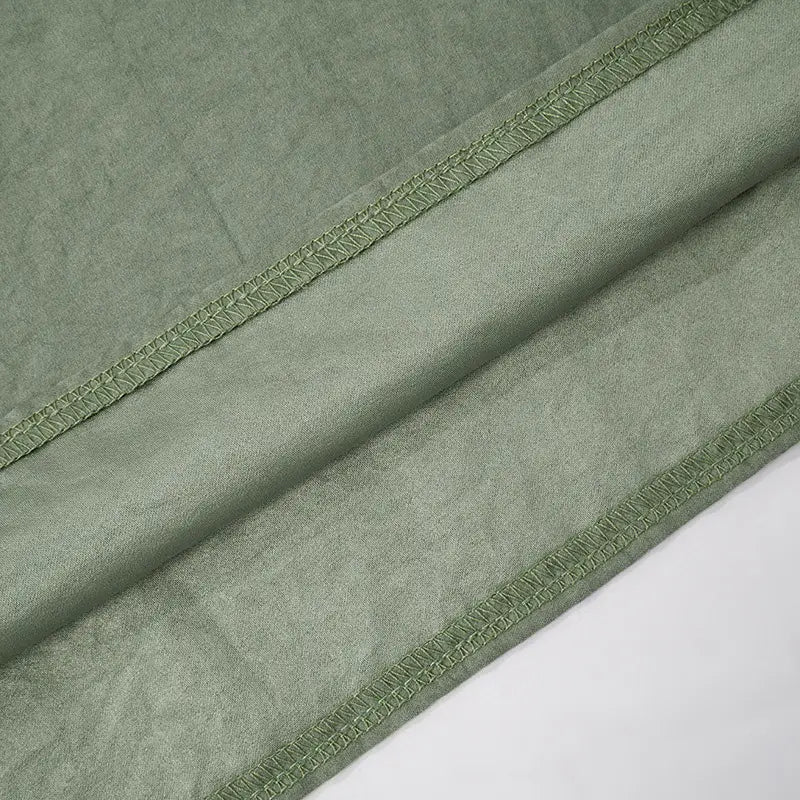 a soft sage green fabric with subtle texture and neatly stitched edges for a lace backless tube featuring sling stitching ruffle and stitching ruffle hip design