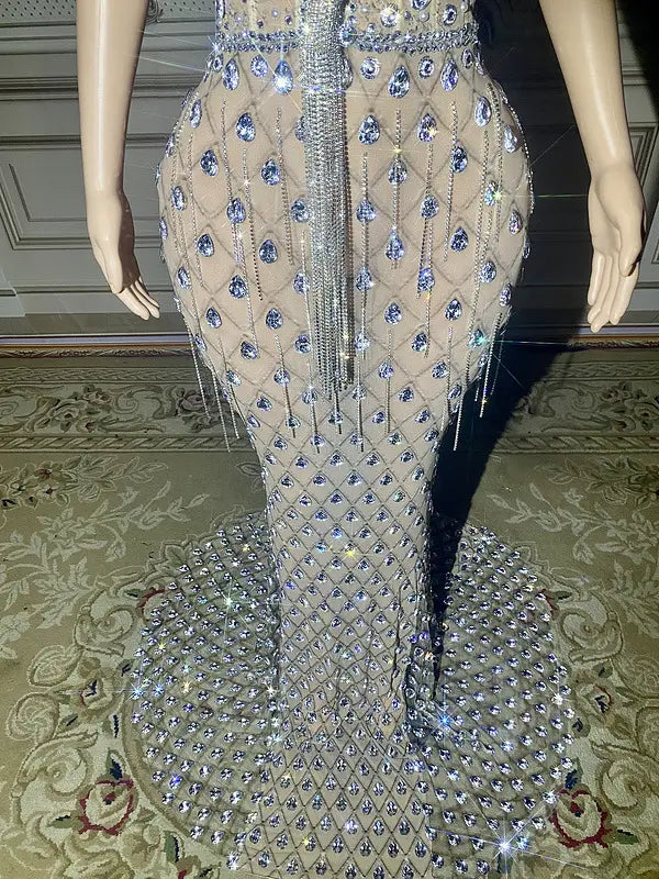 A shimmering silver beaded sexy elegant fishtail gown with intricate blue crystal embellishments forming a diamond pattern on the sheer mermaid-style bodice and skirt.