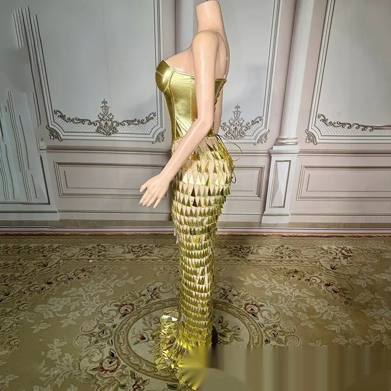 a shimmering gold metallic mermaid-style gown featuring a fitted bodice and cascading scale-like panels with a bright surface bandage design and golden bright surface finish