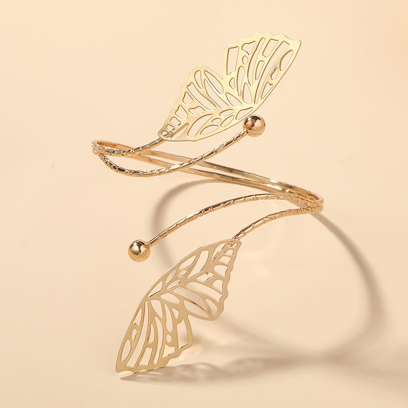 Gold-toned butterfly arm cuff with intricate cut-out wings and small spherical accents designed for a fashion personality trend.