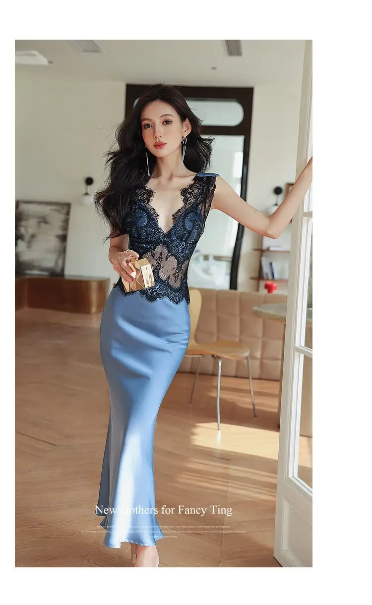 A woman wears a blue sleeveless lace sheath dress featuring a navy blue lace bodice and a satin skirt.