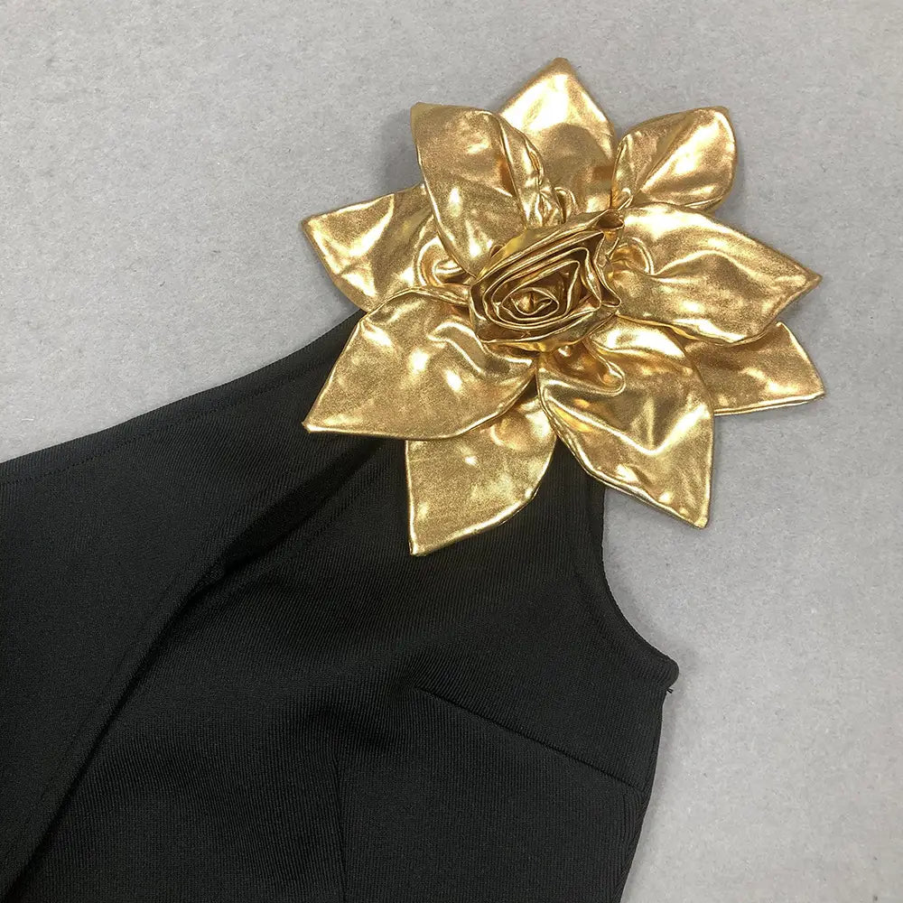 a shiny gold metallic flower brooch with layered petals adorning a black satin bandage golden flower maxi dress