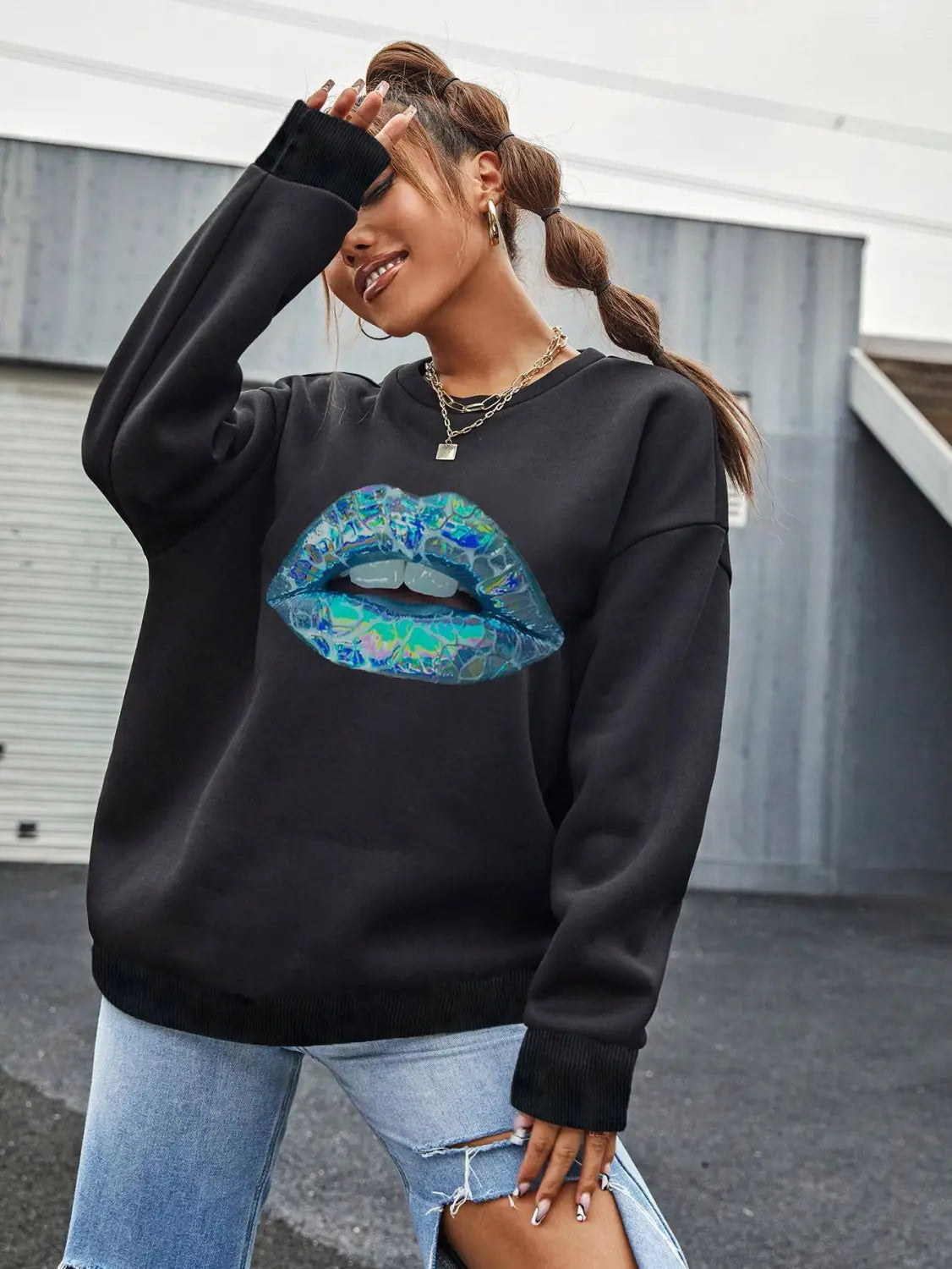 Black crew neck long sleeve sweatshirt for women featuring a vibrant iridescent blue and teal lips graphic.