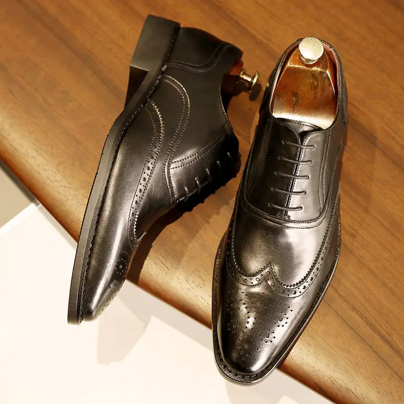 Black leather brogue dress shoes with polished finish decorative perforations and rubber sole suitable for formal wear.