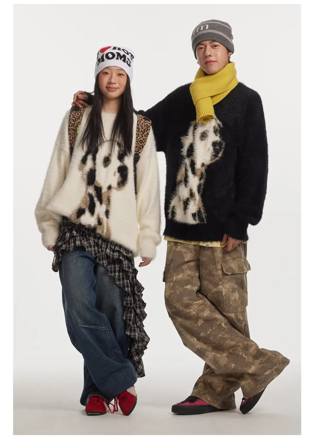 The woman wears a cream-colored dalmatian puppy jacquard mink cashmere knitted sweater featuring black spots and leopard-print shoulder straps.